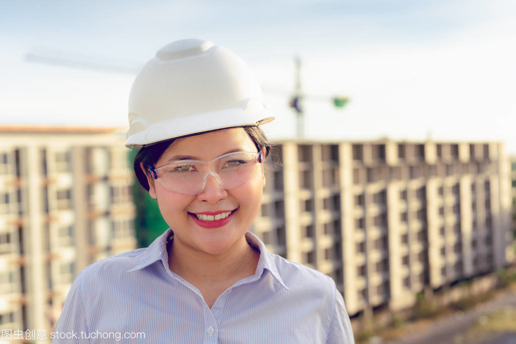 日落背景后建筑工地前土建工程女人員的特寫(xiě)畫(huà)像